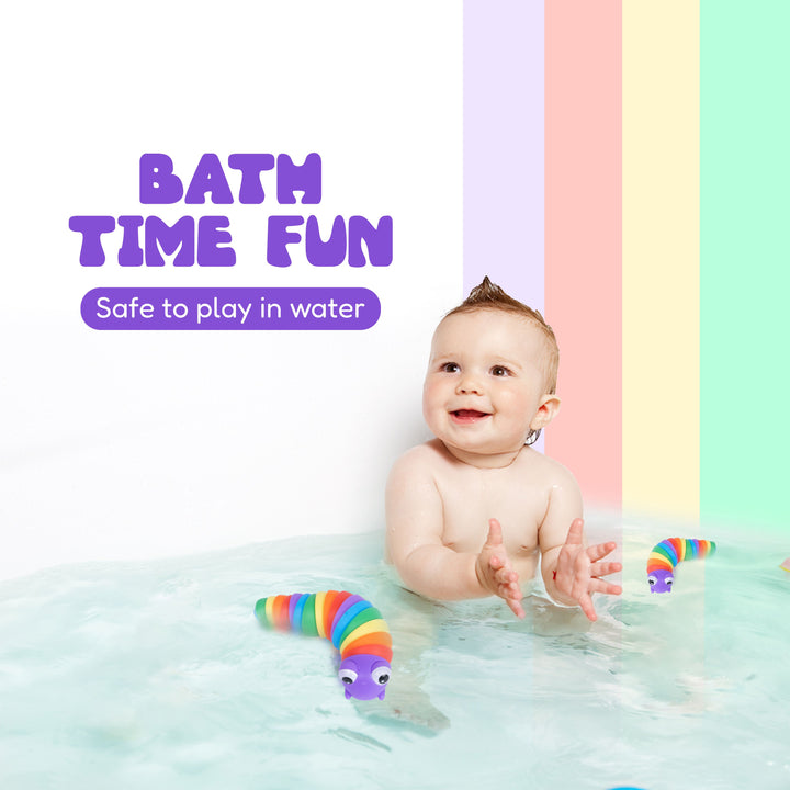 A baby sitting in shallow water with a rainbow-colored worm toy floating nearby. Purple text on the left reads 'BATH TIME FUN' and 'Safe to play in water.