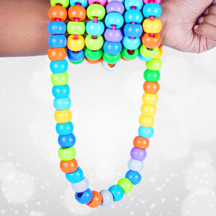 Colorful beaded necklace held by a hand on a white background