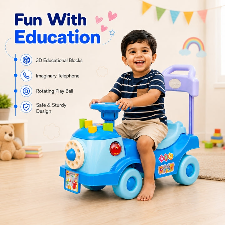 A smiling young child sits on a blue and purple ride-on toy truck in a bright indoor playroom. The toy has colorful educational blocks, a steering wheel, a small red light, and a handlebar.
