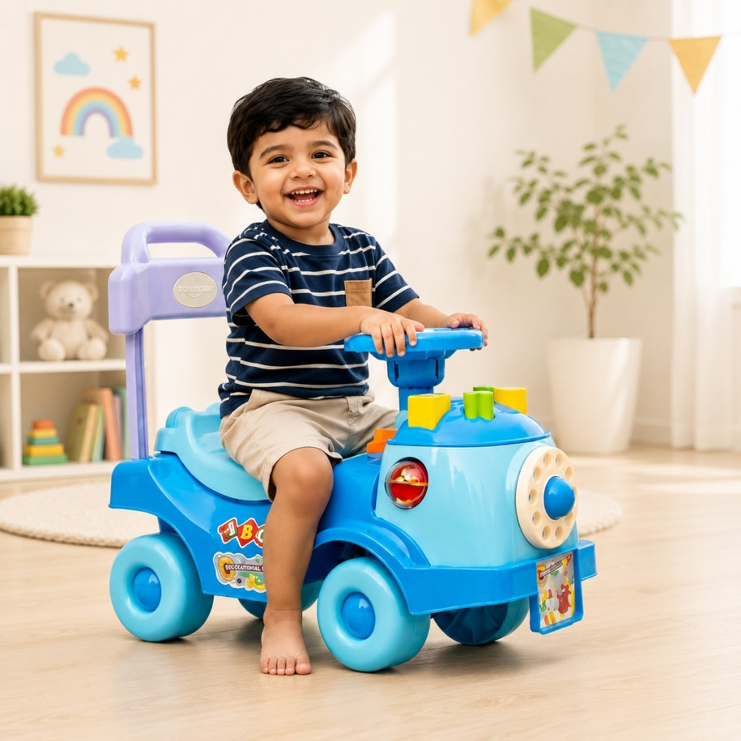 A smiling young boy sits barefoot on a bright blue and purple toy ride-on truck in a sunlit children's room. The truck has colorful details, including a purple handle, blue wheels, and decorative stickers on the side.