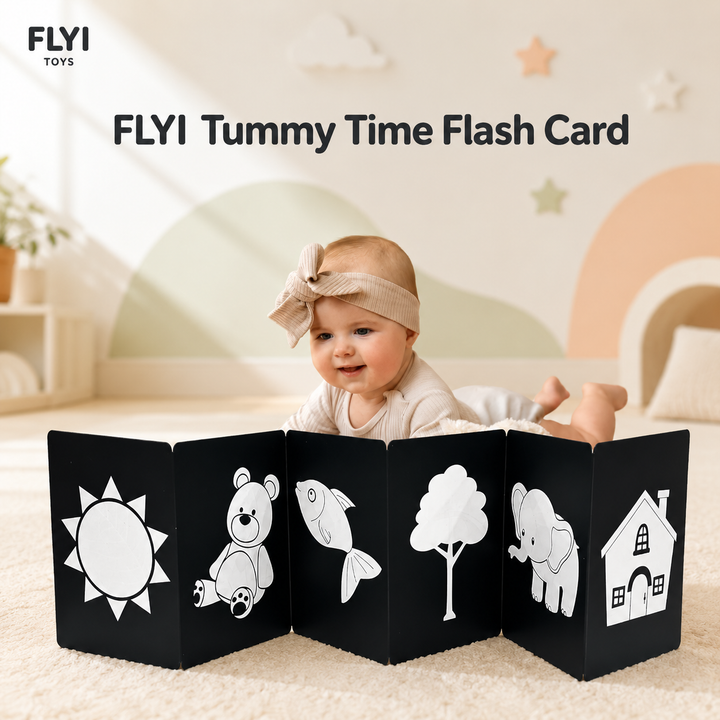 A baby lies on a carpeted floor behind a black interactive flash card toy with white illustrations of a sun, teddy bear, fish, tree, elephant, and house. The FLYI Toys logo and the text 'FLYI Tummy Time Flash Card' appear in the top left, with a soft nursery background.